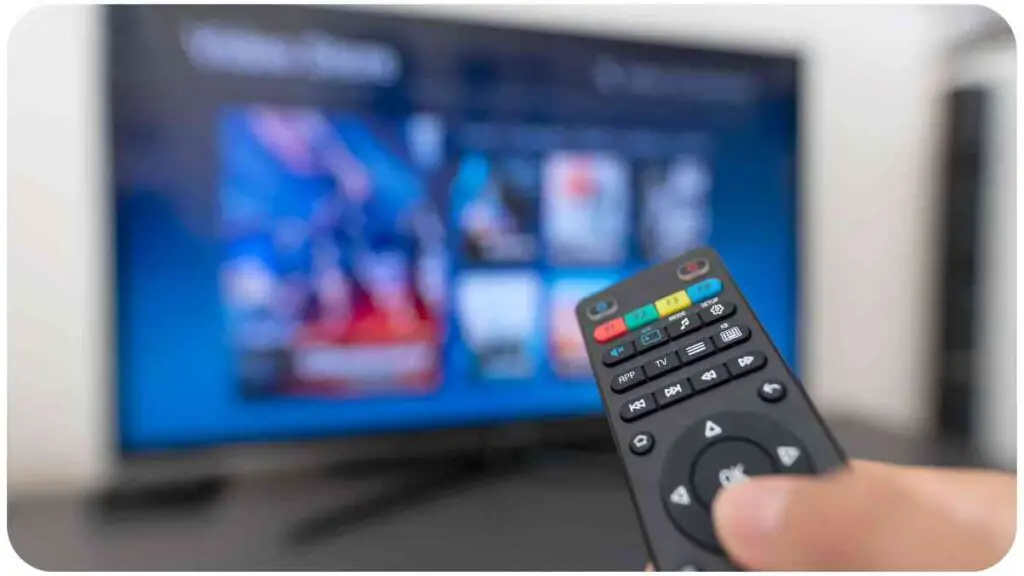 a person holding a remote control in front of a television